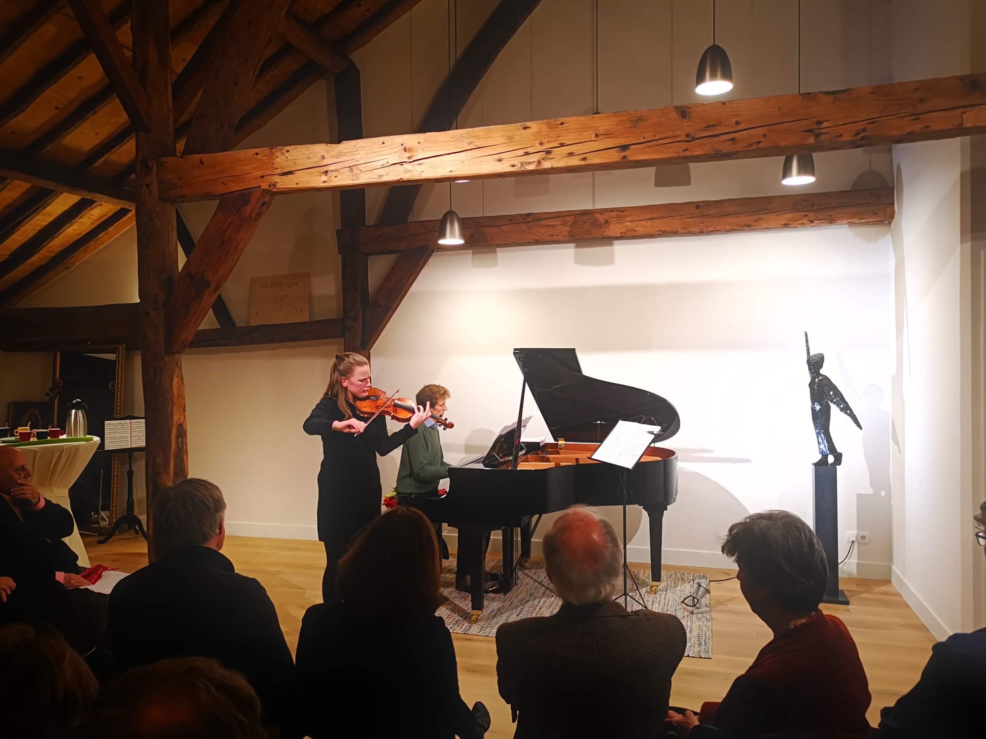 Violiste en pianist spelen onder de eiken balken
